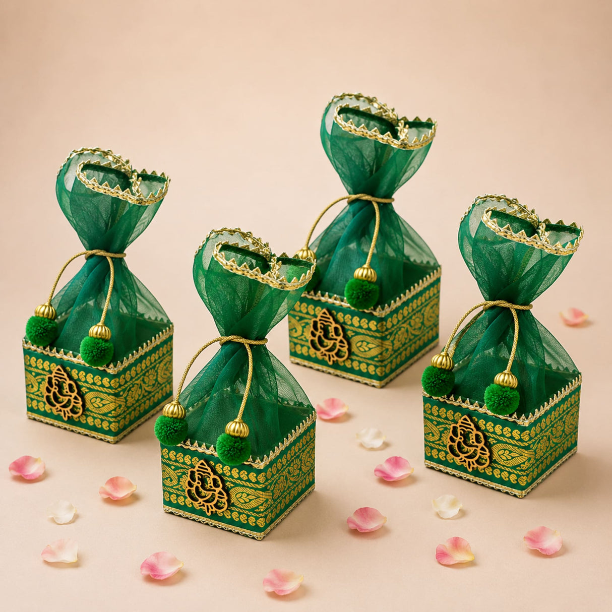 Pack of 4 green and gold ornate potli gift boxes with sheer organza tops tied with golden strings and green pom-poms for indian wedding favors