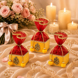 Pack of 4 small red and gold net potli gift boxes with embroidered ganesha motifs and yellow pompom accents for indian festivities