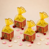 Pack of 4 small red and gold ornate potli gift boxes with golden ganesha motifs and yellow organza bows for indian festivals