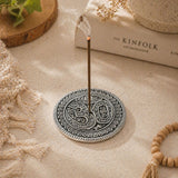 Silver-toned aluminum circular incense holder with intricate paisley mandala patterns and central om symbol for temple decor