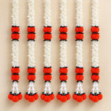 Artificial jasmine marigold garland with white flowers, orange pom-poms, and black connectors for festive decorations