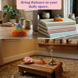 Orgonite pyramid with rainbow-colored seven chakra gemstones and an om symbol for spiritual healing and meditation