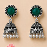 Silver oxidized floral jhumka earrings with green gemstone, clear crystals, and faux pearl dangles for ethnic wear