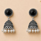 Silver oxidized floral jhumka earrings with black onyx stones and white faux pearl dangles for diwali and weddings