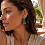 Silver oxidized floral jhumka earrings with turquoise stone, faux pearls, and intricate filigree for ethnic wear