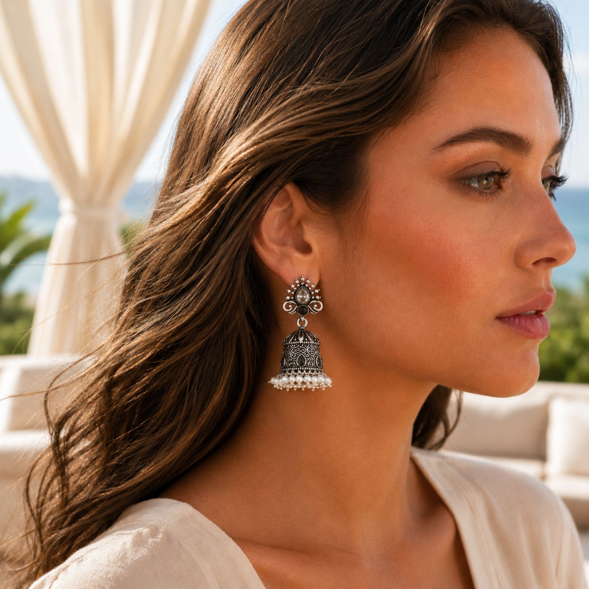 Silver oxidized floral jhumka earrings with intricate filigree, central gemstone, and white pearl dangle for ethnic wear