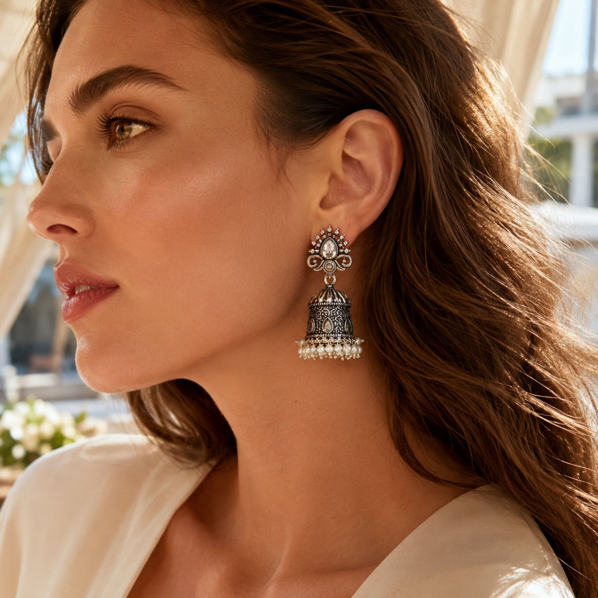 Silver oxidized floral jhumka earring with intricate filigree, central clear stone, and faux pearl fringe for ethnic wear