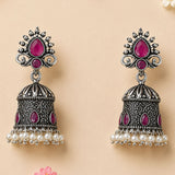 Silver oxidized floral jhumka earrings with intricate filigree, fuchsia gemstones, and white faux pearls for ethnic wear
