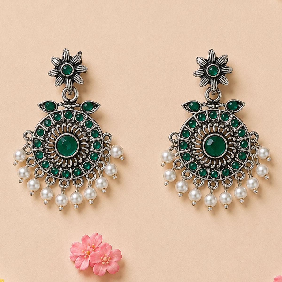 Silver-toned Indian oxidized chandbali earrings with floral design, emerald green gemstones, and white faux pearl drops