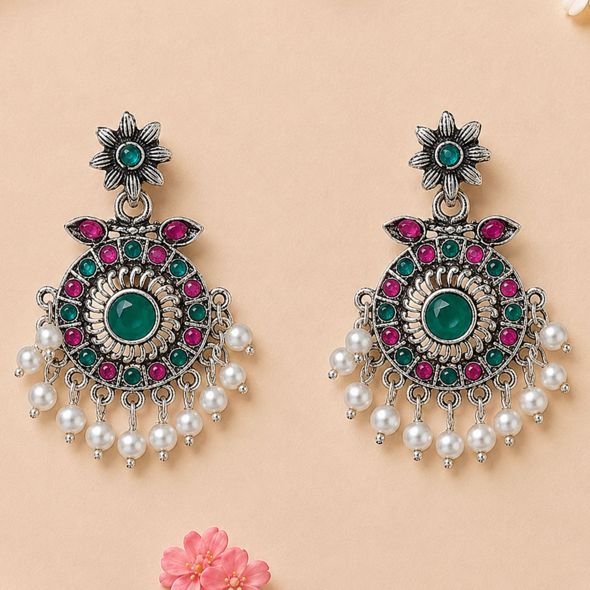Silver oxidized chandbali earrings with central emerald stone, pink and teal gemstones, and dangling white faux pearls for ethnic wear