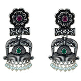 Silver oxidized elephant-themed floral jhumka earrings with ruby and emerald stones and dangling faux pearl beads for ethnic wear