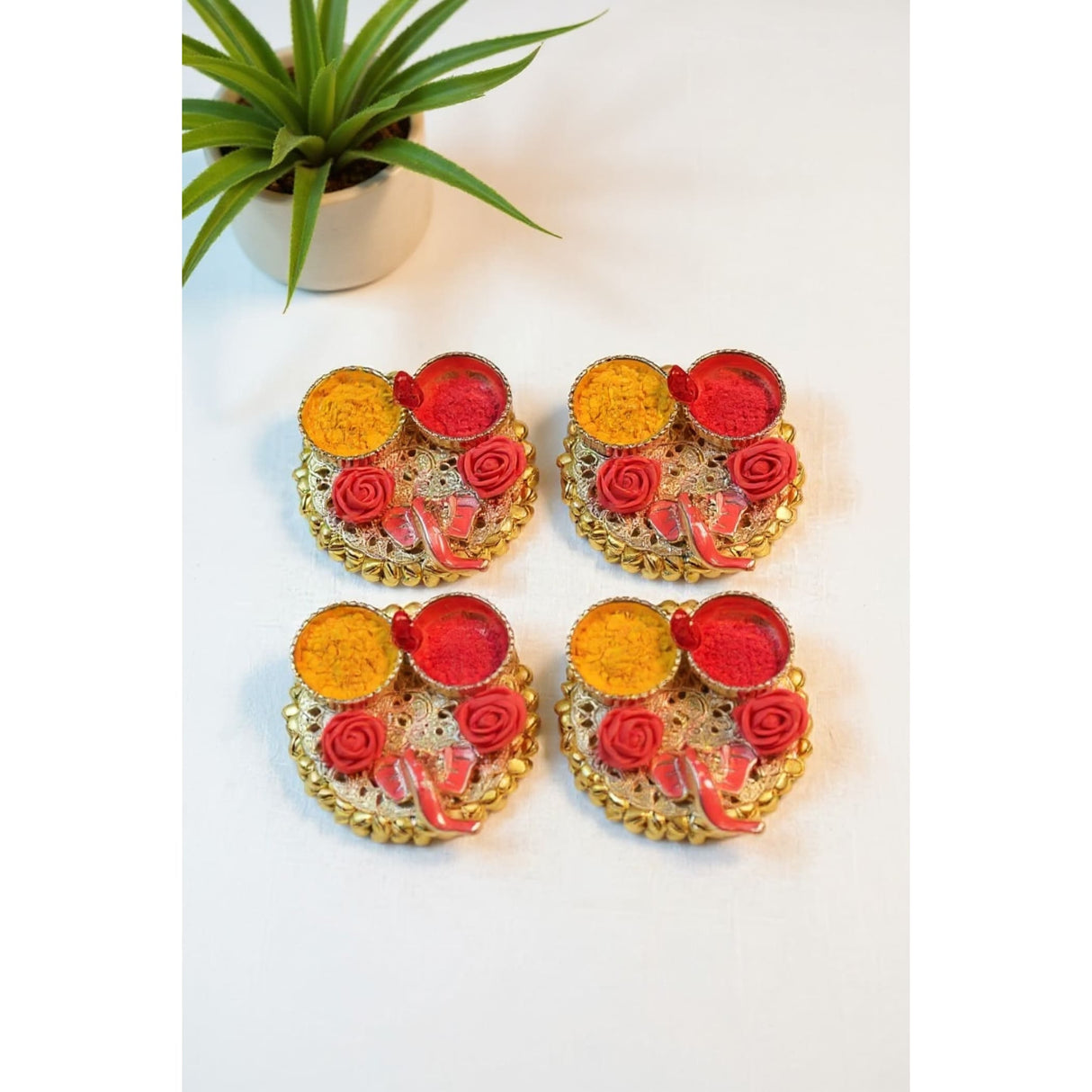 Decorative Indian Rangoli set with vibrant red and yellow powders, floral patterns, and beaded borders for Ganesha Pooja gifts