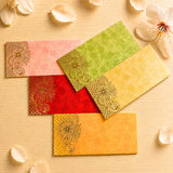 Set of five colorful ornate money envelopes in pink green red and yellow with gold paisley for indian wedding gifts
