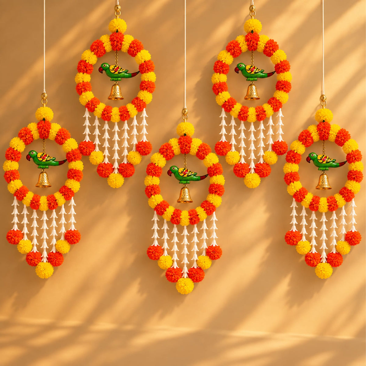 Vibrant orange and yellow marigold pom-pom jhoomer garland with green parrot ornaments and golden bells for festive decor