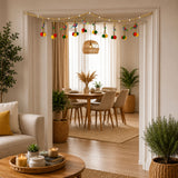 Peacock bead door toran with golden beads and colorful pompom ornaments hanging across a doorway for festive decor