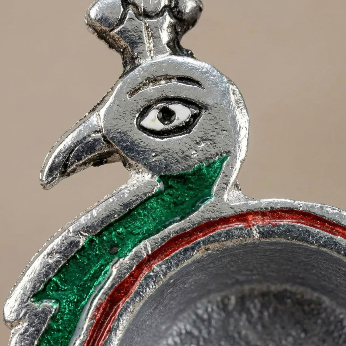 Silver-toned peacock-shaped brass finish diya with green and red enamel accents for diwali puja decor and gifting