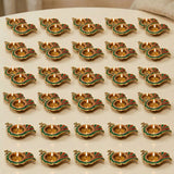 Gold-colored brass peacock diya lamp with green and red enamel accents for diwali puja home decor and gifting