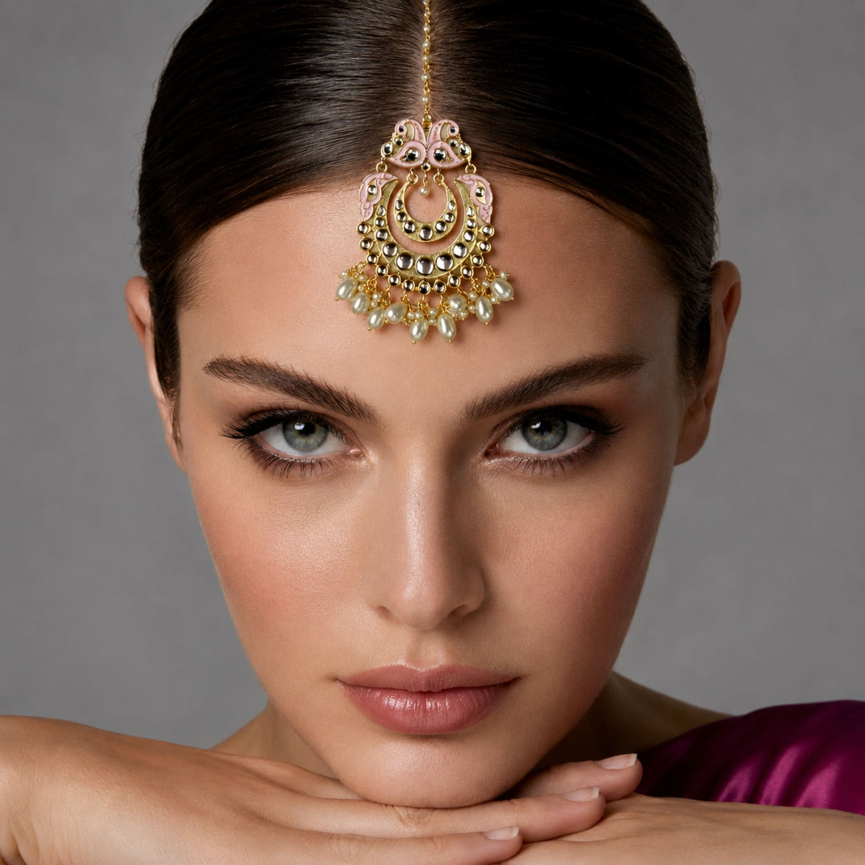 Peacock maang tikka with gold plating featuring gold and pink ornate design adorned with pearls and stones for indian weddings