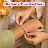 A colorful braided friendship bracelet with red green and yellow threads worn on wrist in Raksha Bandhan gift hamper set