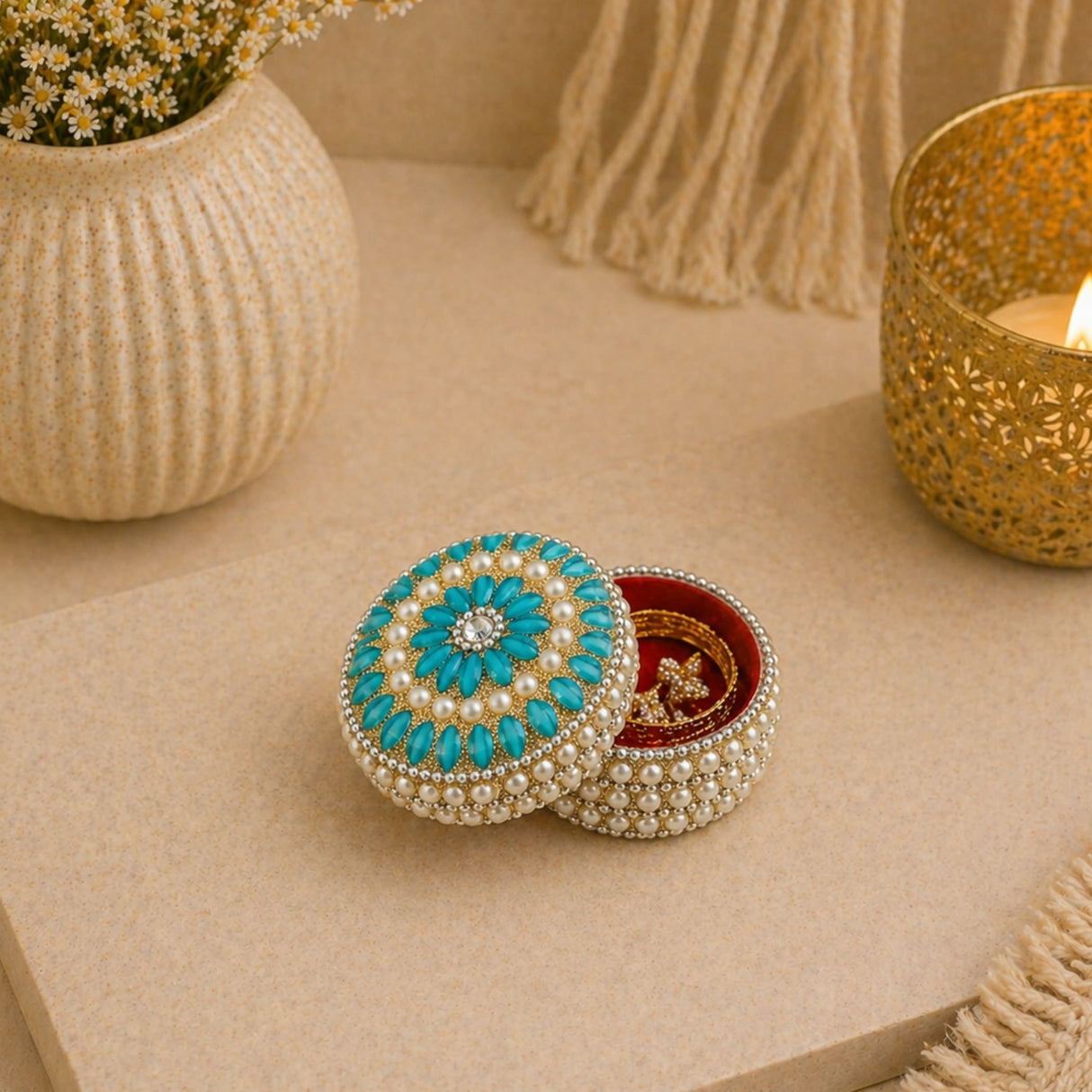 A turquoise circular pearl jewelry box with gold trim floral design and gemstone for Indian festival and wedding gifts