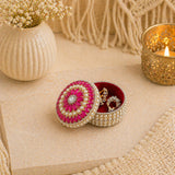 A round pearl jewelry box with vibrant pink and white beaded floral design and diamond accent for festival gifts