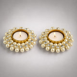 Elegant gold pearl and crystal-adorned pearl t-light holders with lit candles for festive home decor and gifting