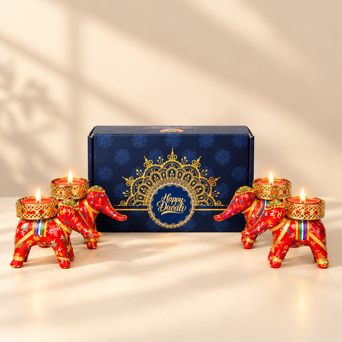 Red and gold elephant-shaped tealight candle holders with intricate patterns from personalized Diwali gifts hamper set