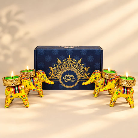 Vibrant yellow elephant-shaped tealight candle holders with floral patterns and gold-trimmed bases for diwali gifts