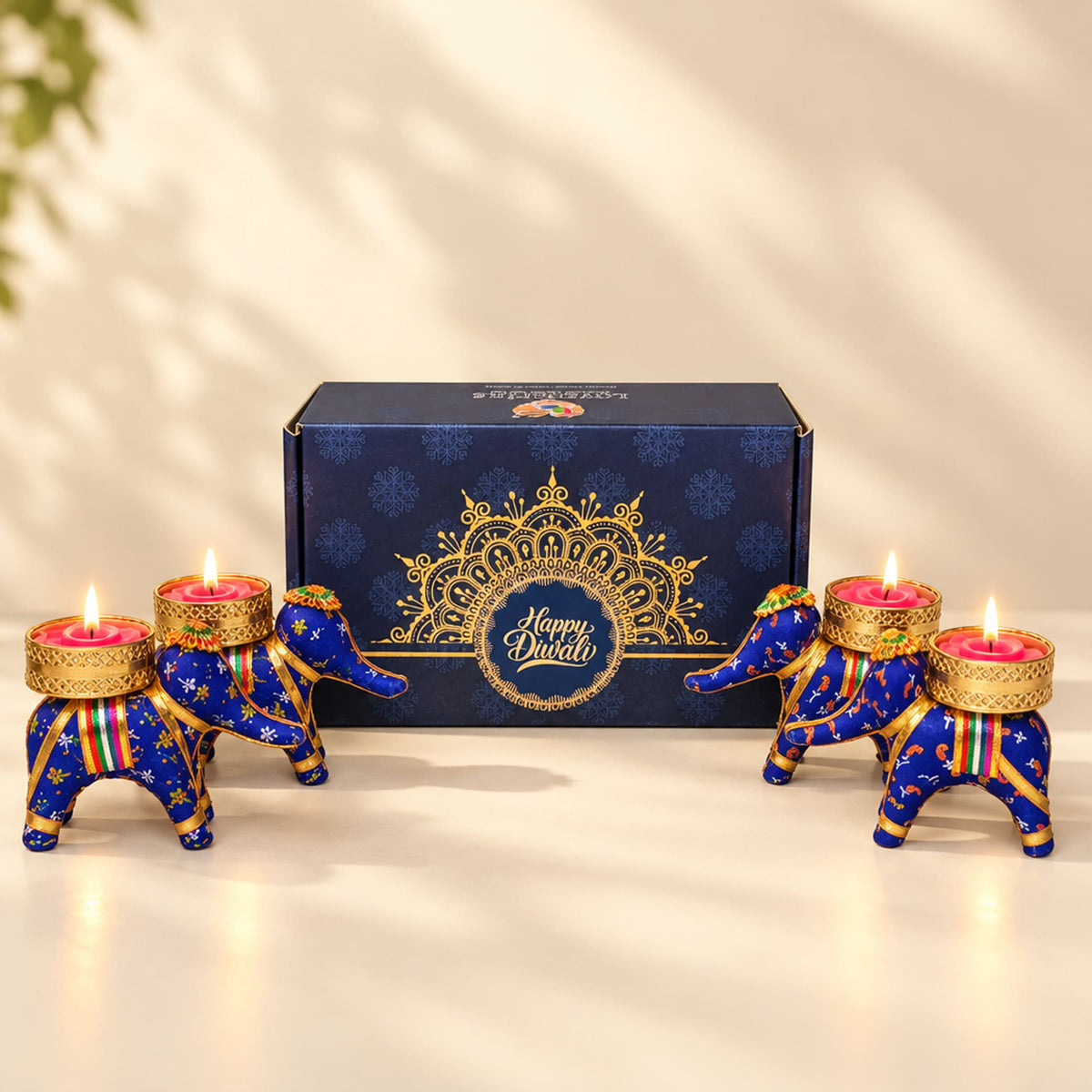 Blue and gold elephant-shaped tealight candle holders with intricate patterns from personalized Diwali gifts hamper set