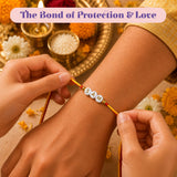 A personalized yellow and red string rakhi with white beads spelling sam placed on wrist for protection and good luck