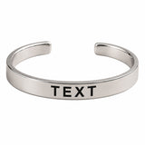 Personalized stainless steel silver-toned open cuff bracelet with smooth finish and engraved black text for raksha bandhan