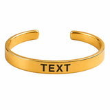 Gold-colored open-ended stainless steel cuff bracelet with engraved black text personalized for raksha bandhan gift