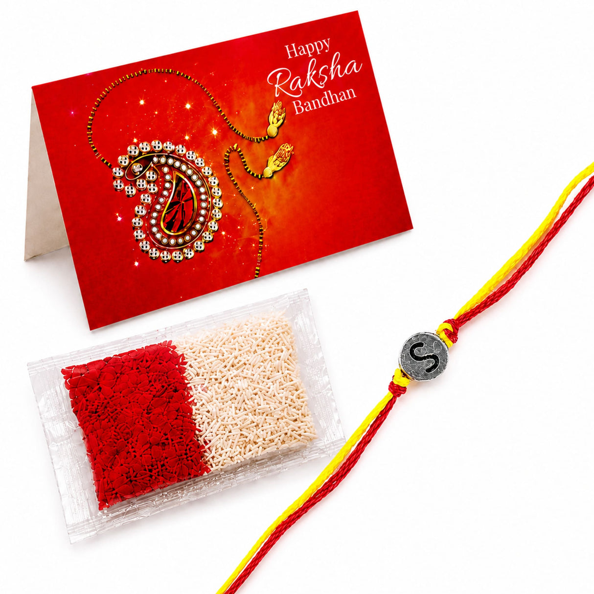 A red and yellow braided designer custom rakhi with a silver charm featuring the letter s for brother and bhabhi