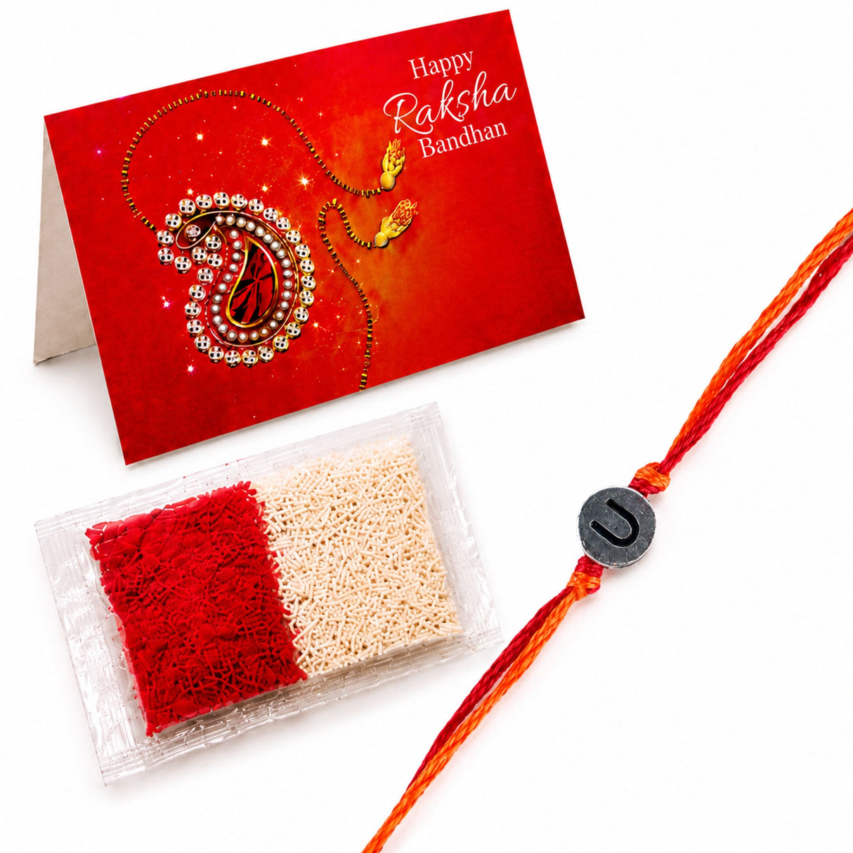 Orange and red braided rakhi with a silver circular charm featuring letter u for brother and bhabhi protection gift