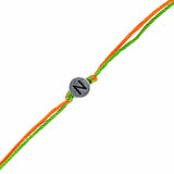 Designer custom single letter rakhi with silver-toned charm engraved with black n on braided orange and green cord