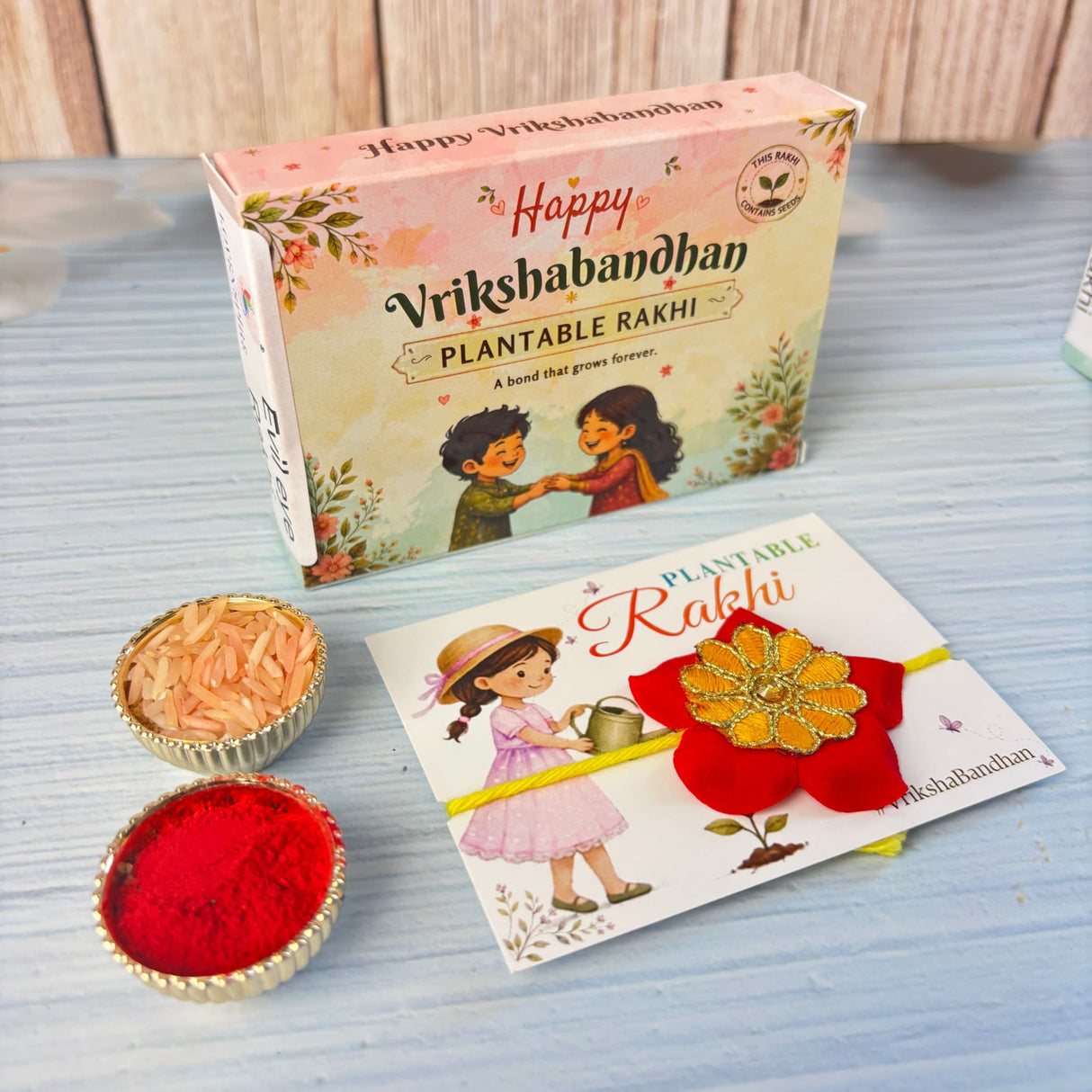 A vibrant red and gold floral plantable seed rakhi with a yellow ribbon eco-friendly for vrikshabandhan gift