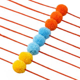 Designer pompom rakhi for god idol featuring vibrant orange blue and yellow fluffy spheres on a red cord