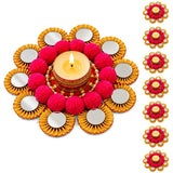Vibrant pink pom-pom and gold-rimmed rangoli mat tealight candle holder with lit tealight for festive decor