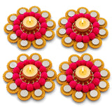 Vibrant pink pom-pom and gold foil-edged rangoli mat tealight candle holders with lit candles for festive décor
