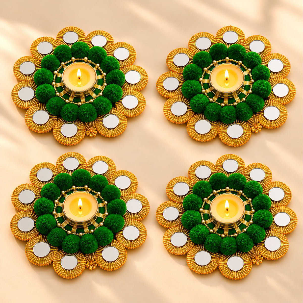 Four ornate tealight holders with gold beaded edges and green pom-pom centers for Diwali pooja decor