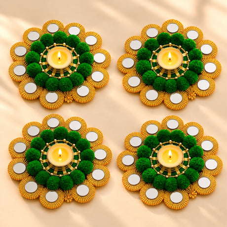 Four ornate tealight holders with gold beaded edges and green pom-pom centers for Diwali pooja decor