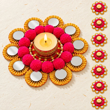 Rangoli mat tealight candle holder in vibrant pink and gold with mirrored petals and lit central diya for festive decor