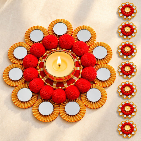 Rangoli mat tealight candle holder with red and gold diya centerpiece, mirrored petals, pom-poms, and lit candle for festive decor