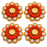 Rangoli mat tealight candle holder featuring gold-toned metallic flower design with orange pom-poms for festive decor