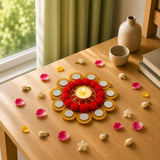 A vibrant red and gold metal tea light candle holder with lit tealight and circular accents for festive home decor