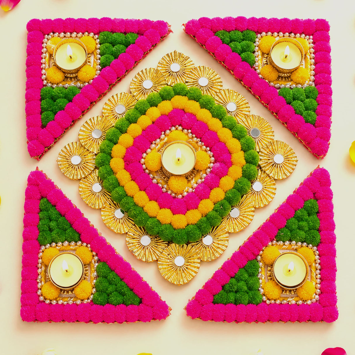 Rangoli mat with vibrant pink green yellow pom-poms gold accents and lit tea light candle holder for festive decor