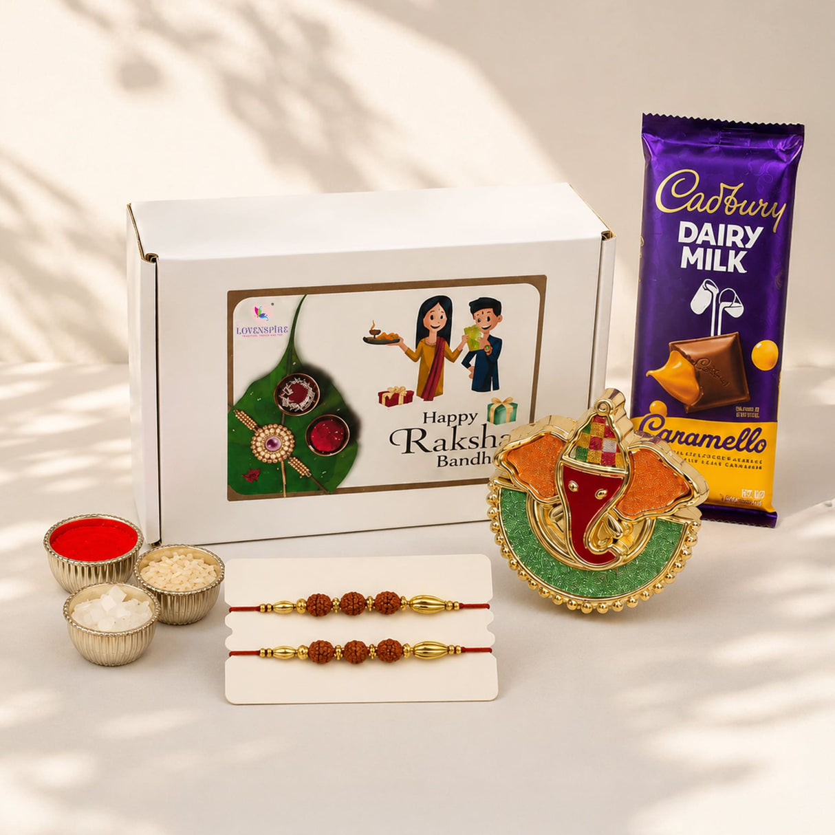Gold and green ornate elephant-shaped raksha bandhan gift set with rudraksha rakhi beads and red thread for brother and bhabhi