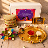 Gold ornate tray with red powder and white rice bowls in bhai dooj gift hamper for brother premium gift box set