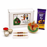 Gold and green ornate ganesha idol with red accents in raksha bandhan gift hamper for brother and bhabhi