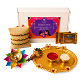 Gold ornate tray with floral embellishments holding two bowls of red powder and white rice in bhai dooj gift hamper